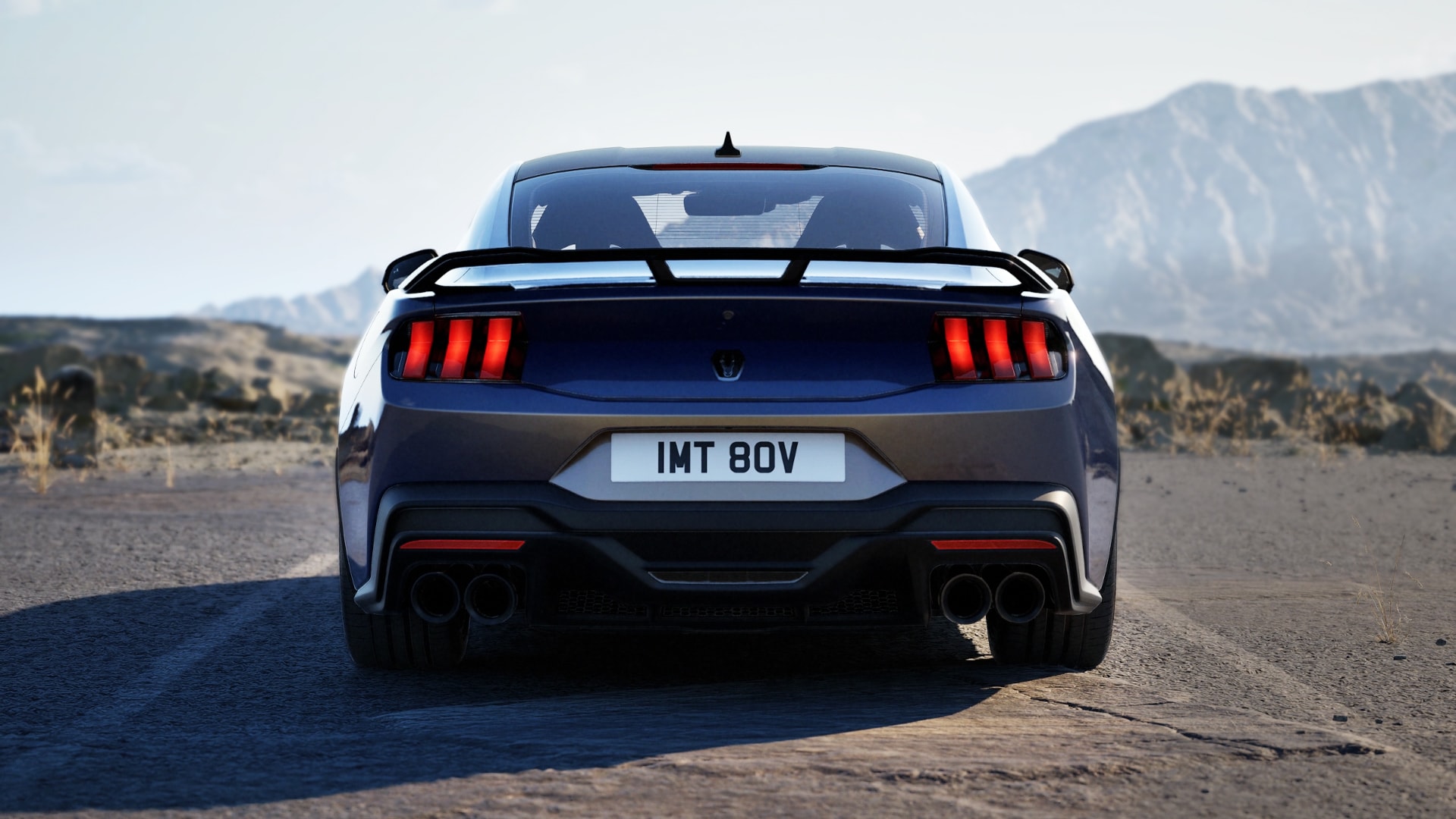 The rear of a Ford Mustang Dark Horse Fastback in Blue Ember paint parked on a mountain road.