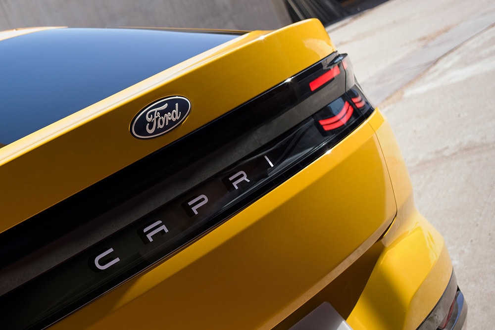 O vedere de aproape a inscripției CAPRI de pe partea din spate a noului SUV electric Ford Capri® galben.
